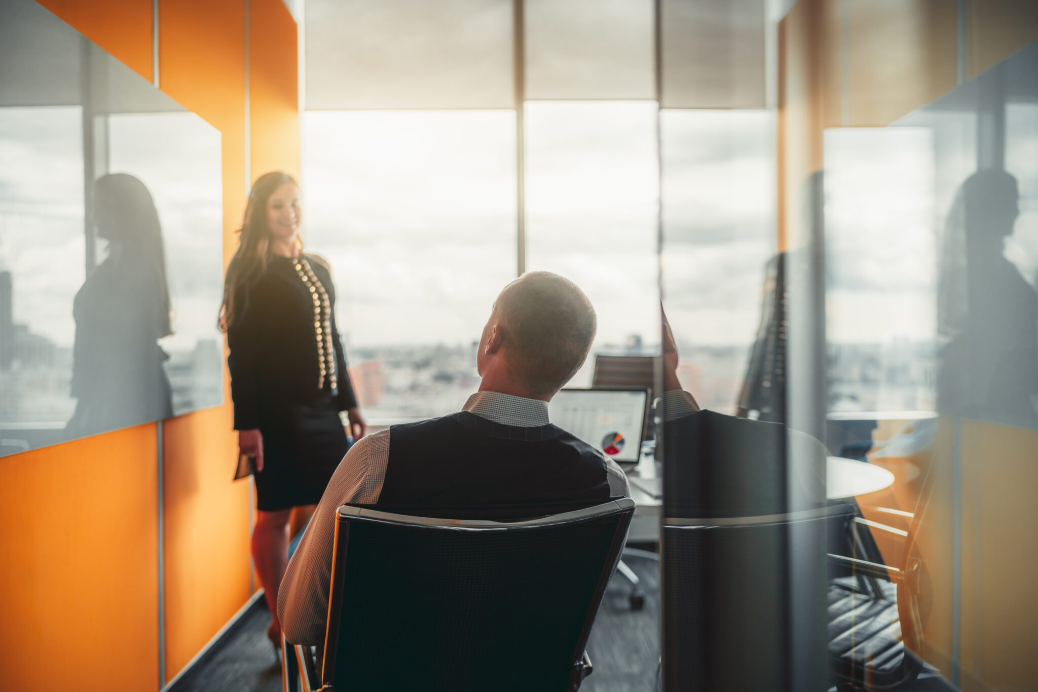 Corporate meeting room with two professionals discussing accounting services, one presenting financial documents to the other