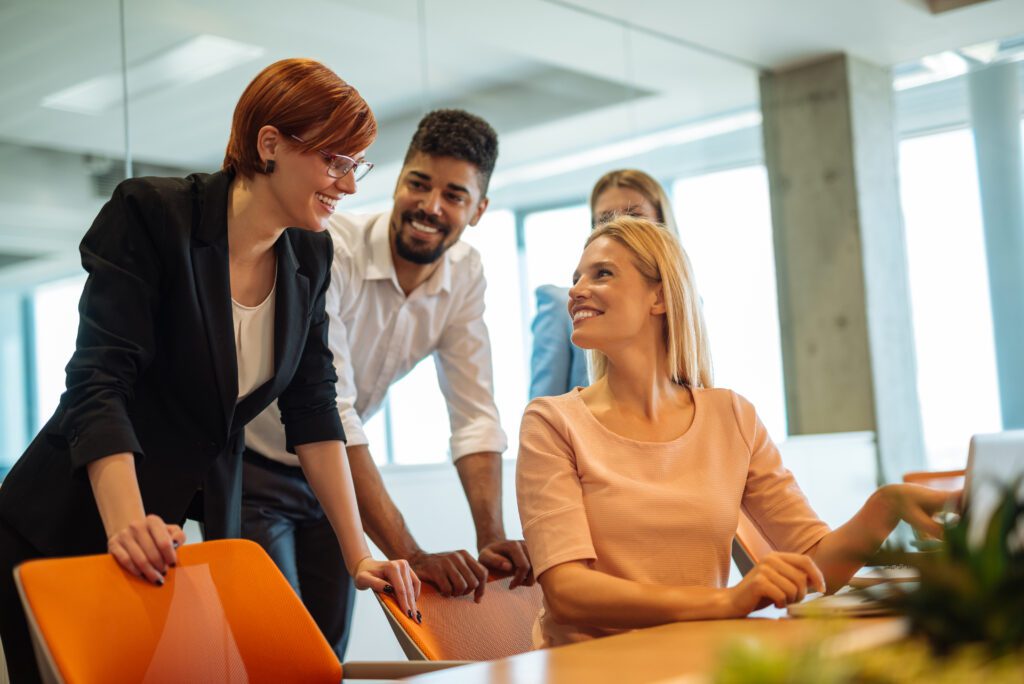 Three professionals engaged in a discussion over a desk, collaborating on family office services and financial planning.